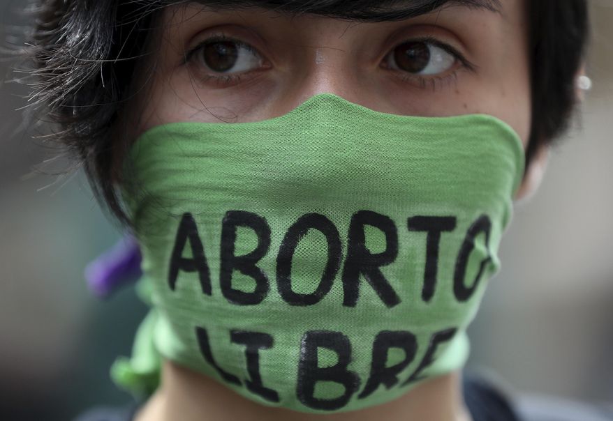 A pro-abortion activist protests in front of Colombia's Constitutional Court in Bogota, Colombia, Monday, March 2, 2020. Protesters gathered in front of Colombia's Constitutional Court ahead of an expected ruling that could allow more women to access abortion if approved. (AP Photo/Fernando Vergara)