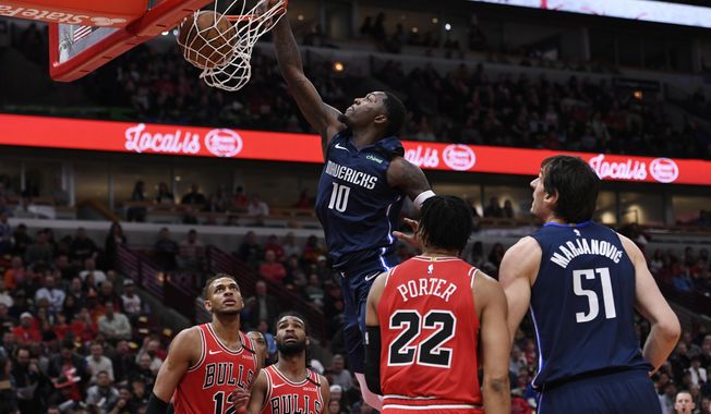Dallas Mavericks&#x27; Dorian Finney-Smith (10) dunks during the first half of an NBA basketball game against the Chicago Bulls, Monday, March 2, 2020, in Chicago. (AP Photo/Paul Beaty)