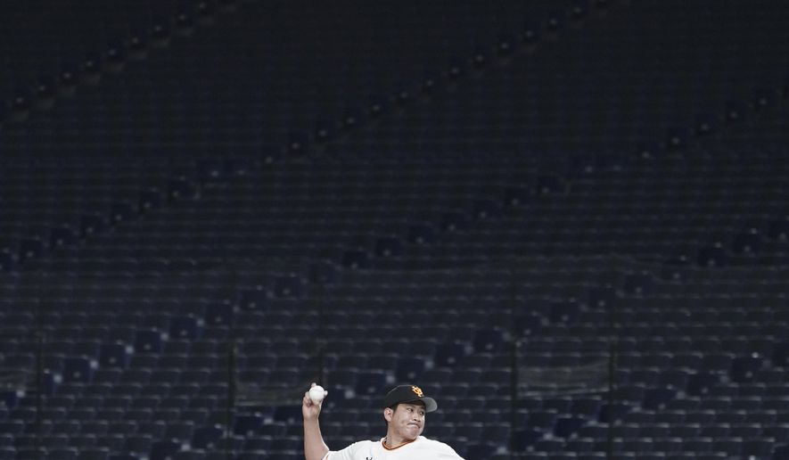FILE - Tomoyuki Sugano of the Yomiuri Giants pitches in front of empty stands at Tokyo Dome in Tokyo during a preseason baseball game between the Yomiuri Giants and the Yakult Swallows on Saturday, Feb. 29, 2020. Japan's professional baseball league said Thursday, Feb. 27, that it will play its 72 remaining preseason games in empty stadiums because of the threat of the spreading coronavirus. (AP Photo/Eugene Hoshiko, File)