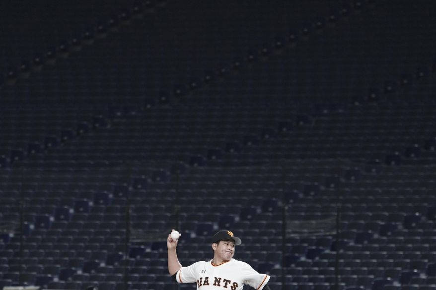 FILE - Tomoyuki Sugano of the Yomiuri Giants pitches in front of empty stands at Tokyo Dome in Tokyo during a preseason baseball game between the Yomiuri Giants and the Yakult Swallows on Saturday, Feb. 29, 2020. Japan's professional baseball league said Thursday, Feb. 27, that it will play its 72 remaining preseason games in empty stadiums because of the threat of the spreading coronavirus. (AP Photo/Eugene Hoshiko, File)