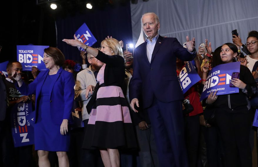Democratic presidential candidate former Vice President Joe Biden, right, is joined by former rival Sen. Amy Klobuchar, left, during a campaign stop in Dallas, Monday, March 2, 2020. At center is Jill Biden. (AP Photo/Eric Gay)