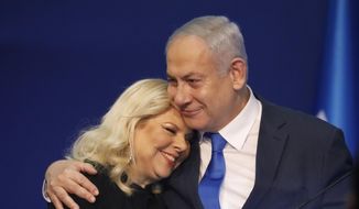 Israeli Prime Minister Benjamin Netanyahu hugs his wife Sara after first exit poll results for the Israeli elections at his party&#39;s headquarters in Tel Aviv, Israel, Monday, Feb. 2, 2020. (AP Photo/Ariel Schalit)