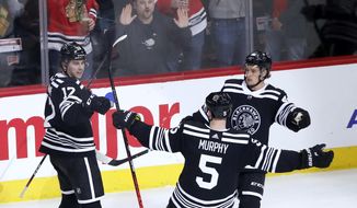 Chicago Blackhawks&#x27; Dylan Strome (17) celebrate his second goal of the night with Connor Murphy (5) and Lucas Carlsson during the second period of the team&#x27;s NHL hockey game against the Anaheim Ducks on Tuesday, March 3, 2020, in Chicago. (AP Photo/Charles Rex Arbogast)