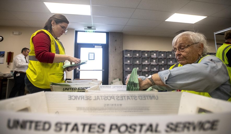 Election judges Anna Troyer, left, and Janet Cook sort ballots by party-affiliated and unaffiliated status as they are received at the Weld County ballot counting center in the Chase Bank building during the state's primary election, Tuesday, March 3, 2020, in Greeley, Colo. (Alex McIntyre/The Greeley Tribune via AP)