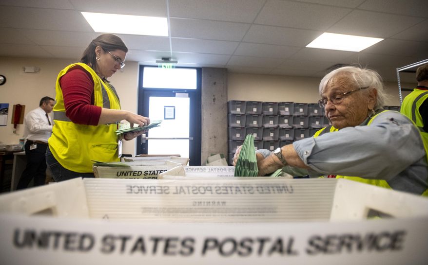 Election judges Anna Troyer, left, and Janet Cook sort ballots by party-affiliated and unaffiliated status as they are received at the Weld County ballot counting center in the Chase Bank building during the state's primary election, Tuesday, March 3, 2020, in Greeley, Colo. (Alex McIntyre/The Greeley Tribune via AP)
