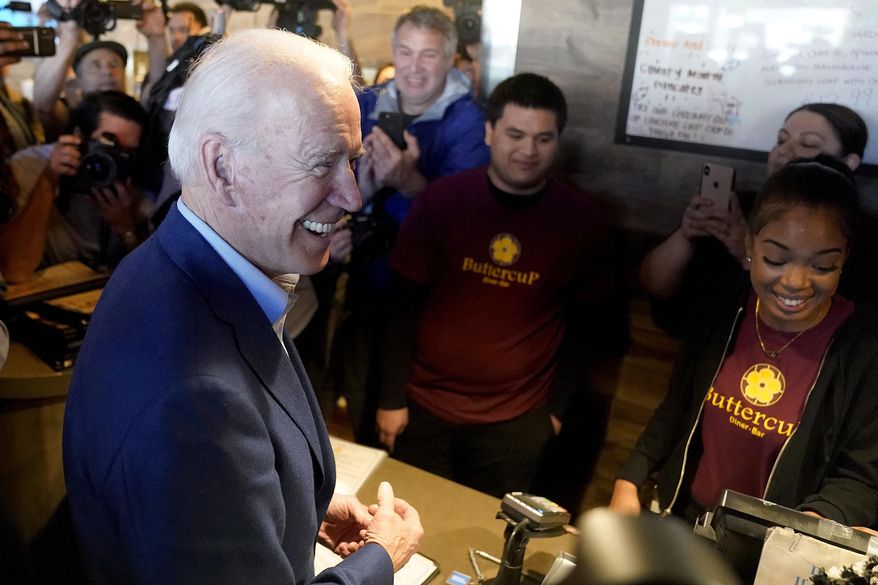 Democratic presidential candidate former Vice President Joe Biden, left, greets employees at the Buttercup Diner during a campaign stop in Oakland, Calif., Tuesday, March 3, 2020. (AP Photo/Tony Avelar)