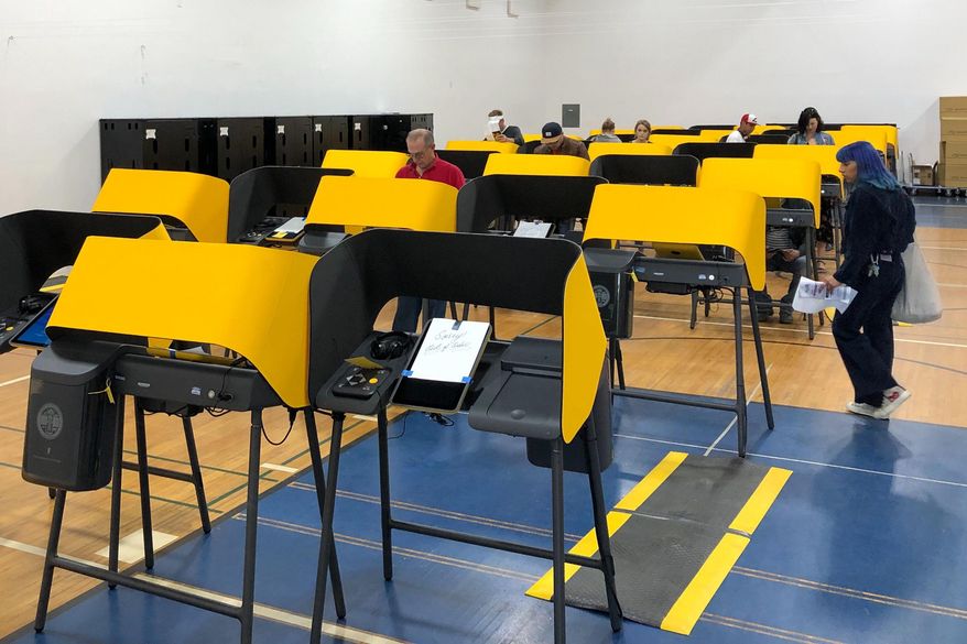 A sign reads "Sorry, Out of Order," on a voting station as people cast the ballots Tuesday, March 3, 2020, at the Silverlake Independent Jewish Community Center in Los Angeles. (AP Photo/Justin Pritchard)