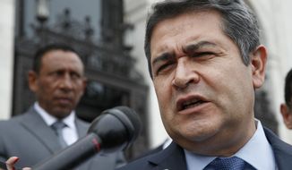 In this Aug. 13, 2019 file photo, Honduran President Juan Orlando Hernandez answers questions from the Associated Press, as he leaves a meeting at the Organization of American States, in Washington. U.S. prosecutors said on Tuesday, March 3, 2020, that Hernandez met with an Honduran drug dealer in 2013 and agreed to facilitate the use of Honduran armed forces personnel as security for the dealer’s drug trafficking activities. In 2013, Hernandez was a congressman. He was elected president at the end of that year. (AP Photo/Jacquelyn Martin, File)