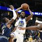 Golden State Warriors Andrew Wiggins (22) looks to make a pass as Denver Nuggets Will Baton lll (5) defends during the first half of an NBA basketball game Tuesday, March 3, 2020 in Denver (AP Photo/John Leyba)