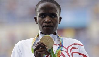 FILE - In this Monday, Aug. 15, 2016 file photo, Bahrain&#x27;s Ruth Jebet shows off her gold medal during the ceremony for the women&#x27;s 3000-meter steeplechase final at the 2016 Summer Olympics at the Olympic stadium in Rio de Janeiro, Brazil. Olympic champion Jebet, the Kenya-born athlete who competes for Bahrain, has been banned four years for doping. She tested positive for the stamina-boosting drug EPO in a sample she gave in Dec. 2017. (AP Photo/Natacha Pisarenko, file)