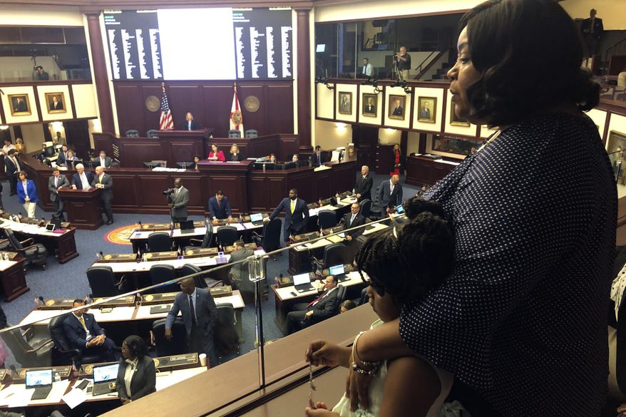 Meralyn Kirkland holds her granddaughter Kaia Rolle as legislaors work on the House floor, Wednesday, March 4, 2020, in Tallahassee, Fla. Florida lawmakers rallied behind a 6-year-old Rolle who was zip-tied at school and arrested last fall, and on Wednesday inserted an amendment into a school safety bill to require authorities to disclose their policies and procedures for arresting children under 10 years old. The scene generated public outrage when footage from a police body camera showed the crying young girl pleading with the arresting officer for "a second chance." (AP Photo/Bobby Caina Calvan)