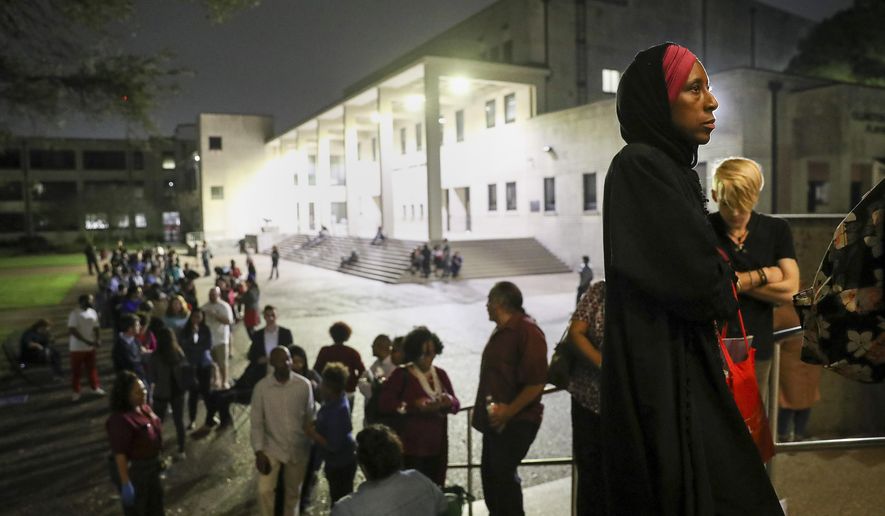 "I can remember when I did not have the right to vote," said Nancy Glenn Griesinger, second from right, when asked why she waited so long in line to vote Tuesday, March 3, 2020, at Texas Southern University in Houston. After 10 p.m., a line of people still stretched out of the Robert James Terry Library as they waited to cast their votes. (Jon Shapley/Houston Chronicle via AP)
