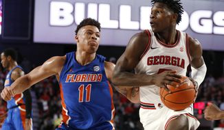 Georgia&#39;s Anthony Edwards (5) moves the ball pasy Florida forward Keyontae Johnson (11) during the first half of an NCAA college basketball game Wednesday, March 4, 2020, in Athens, Ga. (Joshua L. Jones/Athens Banner-Herald via AP)