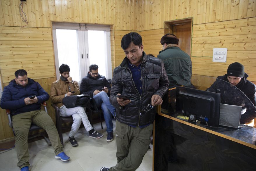 FILE - In this Jan. 30, 2020, file photo, Kashmiri journalists browse the internet on their mobile phones inside the media center set up by government authorities in Srinagar, Indian controlled Kashmir. Indian authorities on Wednesday, March 4, temporarily revoked a ban on social media sites and restored full internet access in disputed Kashmir for two weeks, seven months after they stripped the restive region of its statehood and semi-autonomy and enforced a total communications blackout. (AP Photo/Dar Yasin, File)