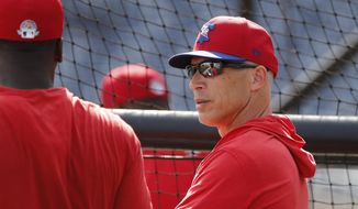 Philadelphia Phillies manager Joe Girardi talks to shortstop Didi Gregorius during pregame of a spring training baseball game, Wednesday, March 4, 2020, in Clearwater, Fla. (AP Photo/Carlos Osorio)