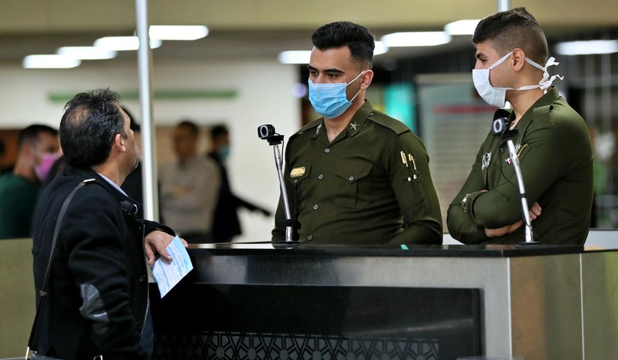 Police officers wear masks at Baghdad Airport, Iraq, Wednesday, March 4, 2020. From religion to sports, countries were taking drastic and increasingly visible measures to curb the new coronavirus that first emerged in China and was spreading quickly through Europe, the Mideast and the Americas. (AP Photo/Hadi Mizban)