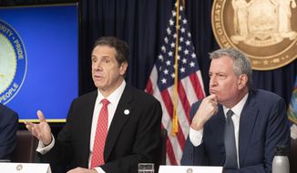 In this Monday, March 2, 2020, file photo, New York Gov. Andrew Cuomo, left, and Mayor Bill de Blasio discuss the state and city&#x27;s preparedness for the spread of the coronavirus, in New York. The wife, two children and neighbor of a New York lawyer who is hospitalized in critical condition with COVID-19 have also tested positive for the disease. Gov. Cuomo made the announcement on Wednesday, March 4.  (AP Photo/Mark Lennihan, File) **FILE**
