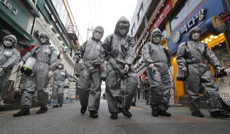 South Korean army soldiers wearing protective gears spray disinfectant as a precaution against the new coronavirus at a shopping street in Seoul, South Korea, Wednesday, March 4, 2020. The coronavirus epidemic shifted increasingly westward toward the Middle East, Europe and the United States on Tuesday, with governments taking emergency steps to ease shortages of masks and other supplies for front-line doctors and nurses. (AP Photo/Ahn Young-joon)