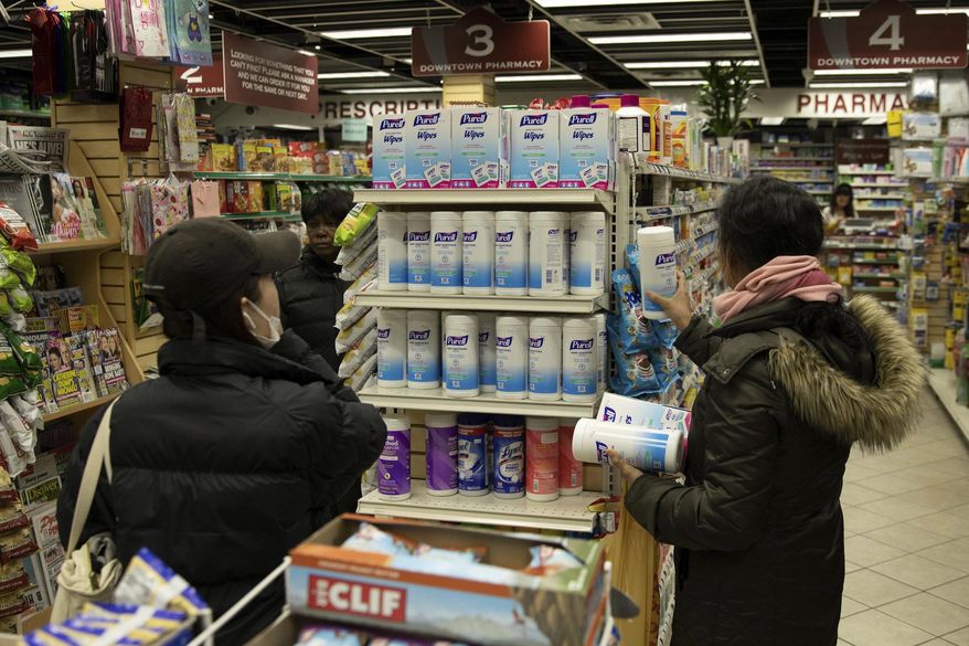 Now a familiar scene: Customers consider sanitizing wipes on the shelves of a pharmacy in New York City. How worried are we? (Associated Press)