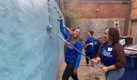 Veterans Jamicka Edwards (left) and Elis Salamone from The Mission Continues&#39; women&#39;s leadership fellowship program repaint the outdoor space at Calvary Women&#39;s Services on Thursday in the District. (Sophie Kaplan/The Washington Times)