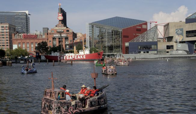 People relax on an electric boat in Baltimore&#x27;s Inner Harbor, Friday, July 5, 2019. After a day of mostly sunshine, the Baltimore area is expected to see showers throughout the weekend. (AP Photo/Julio Cortez)  **FILE**



