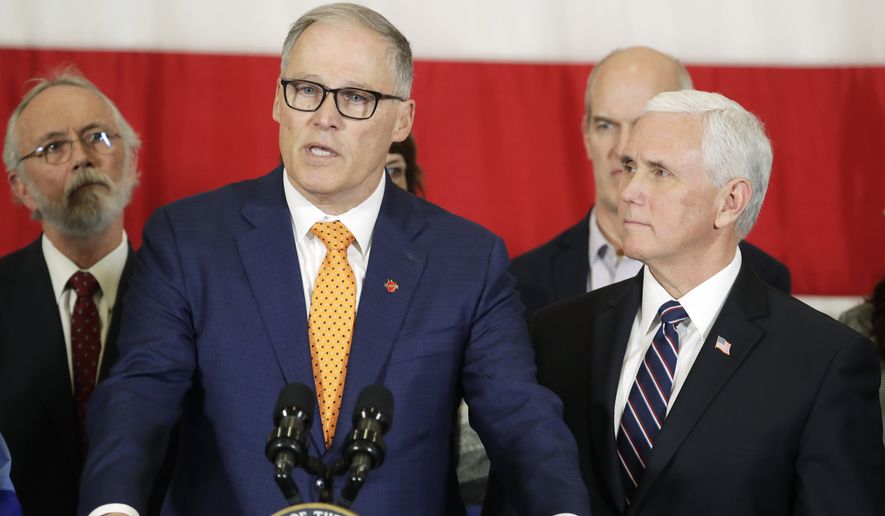 Vice President Mike Pence, right, looks on as Gov. Jay Inslee speaks during a news conference, Thursday, March 5, 2020, at Camp Murray in Washington state. Pence was in Washington to discuss the state&#39;s efforts to fight the spread of the COVID-19 coronavirus. (AP Photo/Ted S. Warren)