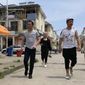 In this June 5, 2019, photo, residents of the Hui Muslim ethnic minority walk in a neighborhood near an OFILM factory in Nanchang in eastern China&#39;s Jiangxi province. The Associated Press has found that OFILM, a supplier of major multinational companies, employs Uighurs, an ethnic Turkic minority, under highly restrictive conditions, including not letting them leave the factory compound without a chaperone, worship, or wear headscarves. (AP Photo/Ng Han Guan)