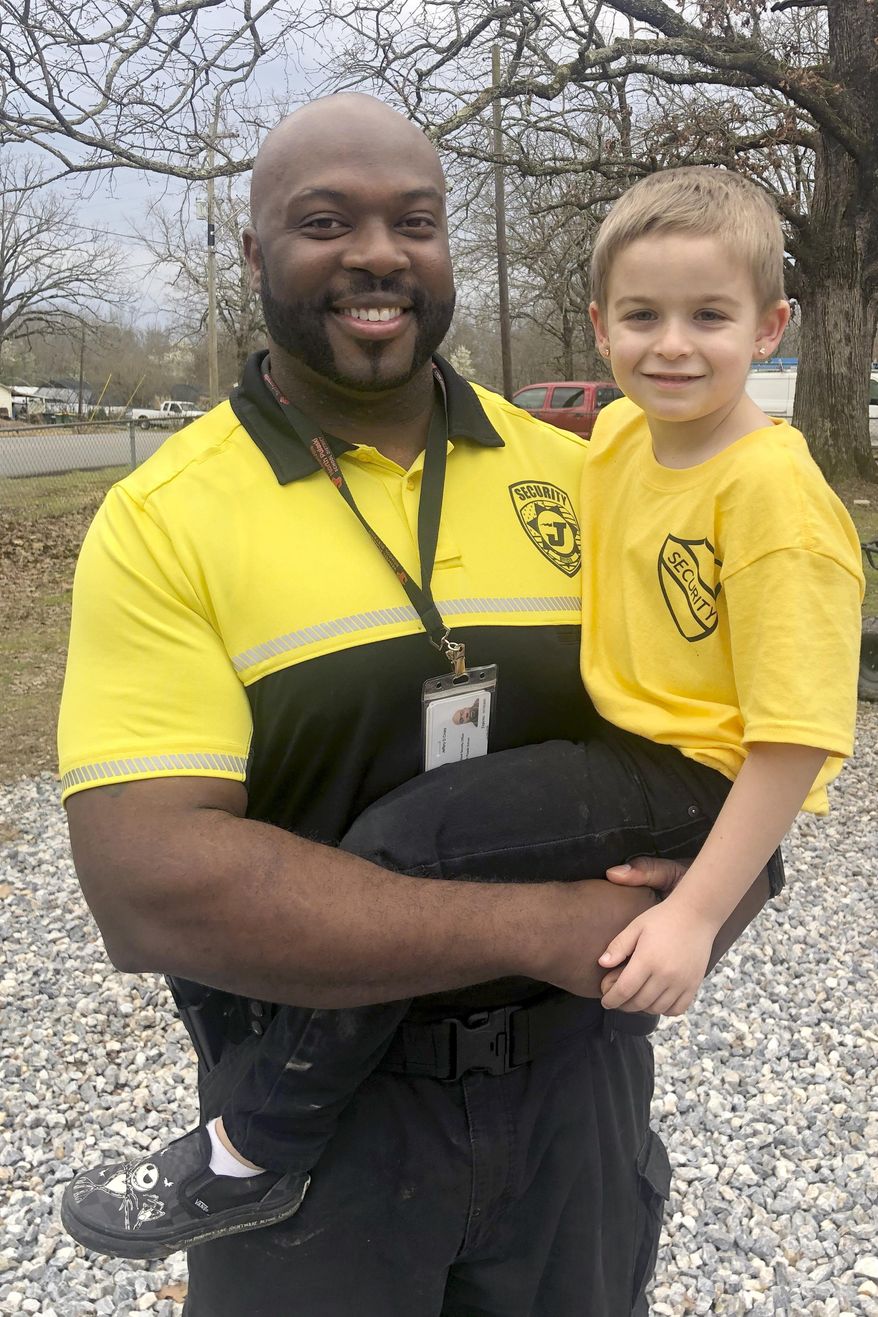 In this Wednesday, March 4, 2020, photo provided by THV11-TV in Little Rock, Ark., Bobby G. Lester Elementary School security officer Jeffery Cross and kindergartener Easton Blocker pose for a portrait in Jacksonville, Ark. Blocker is warming hearts after he decided to dress up as Cross for "Dress As Your Favorite Person Day." Easton's mom Lauryn said, "He tells me every day; Officer Cross keeps us safe from the bad guys, mommy." (Melissa Zygowicz/THV11-TV via AP) (Melissa Zygowicz/THV11-TV via AP)