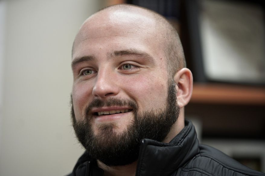 In this March 2, 2020, photo, former Nebraska football player Tanner Farmer and current wrestler for Concordia University smiles during an interview with the Associated Press, in Seward, Neb. A year ago Farmer was thought to be on the rise as an NFL draft prospect. He had started three years on Nebraska's offensive line and turned in a stellar performance at the Cornhuskers' pro day. It turned out he went undrafted, so he took a volunteer assistant's job with the Concordia football team and then, quite by accident, discovered he had one semester of eligibility to compete in another sport in the National Association of Intercollegiate Athletics. He chose wrestling. (AP Photo/Nati Harnik)