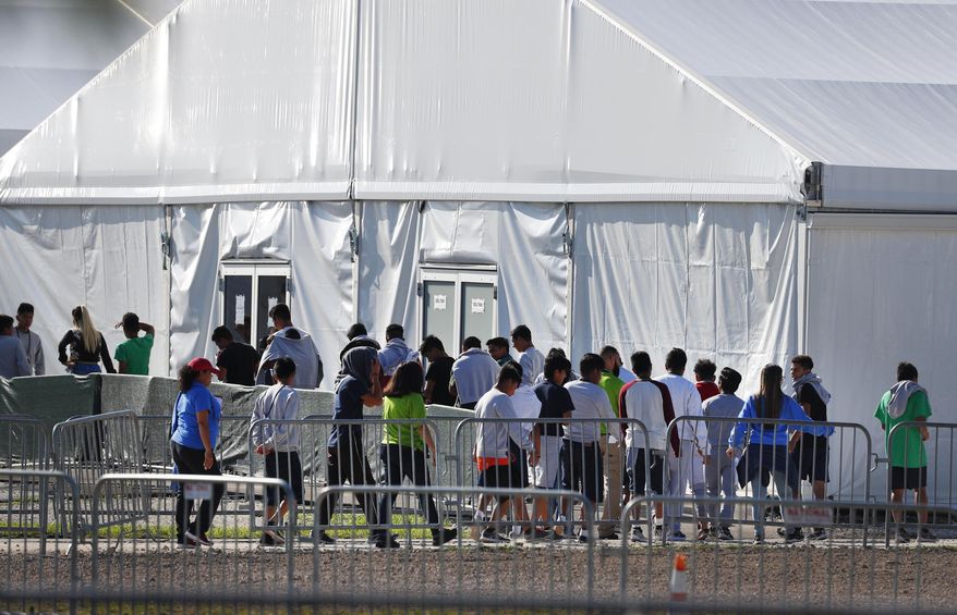 FILE- In this Feb. 19, 2019, file photo, children line up to enter a tent at the Homestead Temporary Shelter for Unaccompanied Children in Homestead, Fla. Despite efforts by the Trump administration to improve communication to track children who are separated from their families at the border, the process is still vulnerable to error and information sharing between agencies is inconsistent, raising questions on the accuracy of current data, a watchdog reported Thursday. (AP Photo/Wilfredo Lee, File)