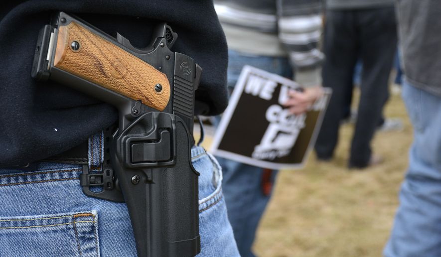 FILE - In this April 5, 2014, file photo, a man open carries a 1911 handgun while at a CCDL gun rights rally at the Connecticut state capitol in Hartford. The Democratic co-chairmen of the Judiciary Committee, Sen. Gary Winfield and Rep. Steve Stafstrom, have introduced a bill to revamp Connecticut's 1999 "red flag" law, which was the first in the country to allow judges to order someone's guns seized upon evidence they are a danger to themselves or others. The bill would add relatives, household members and medical professionals, including physicians, physician assistants, nurses and psychologists. (Mike Orazzi/The Bristol Press via AP, File)