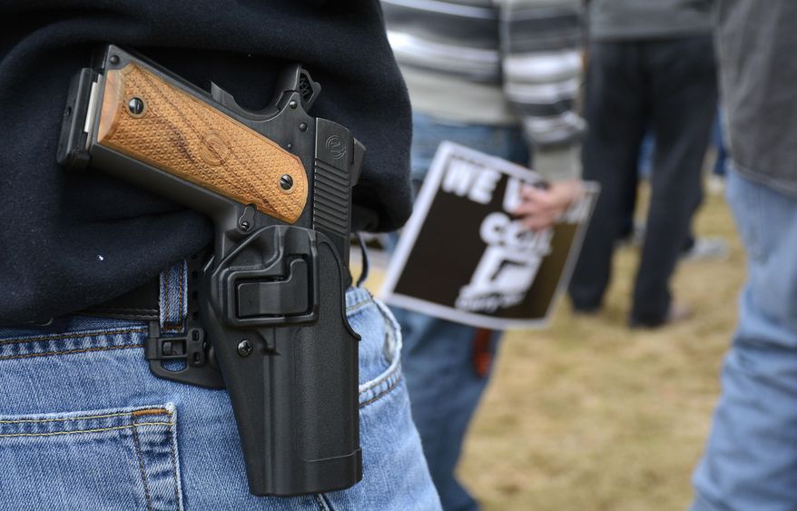 FILE - In this April 5, 2014, file photo, a man open carries a 1911 handgun while at a CCDL gun rights rally at the Connecticut state capitol in Hartford. The Democratic co-chairmen of the Judiciary Committee, Sen. Gary Winfield and Rep. Steve Stafstrom, have introduced a bill to revamp Connecticut's 1999 "red flag" law, which was the first in the country to allow judges to order someone's guns seized upon evidence they are a danger to themselves or others. The bill would add relatives, household members and medical professionals, including physicians, physician assistants, nurses and psychologists. (Mike Orazzi/The Bristol Press via AP, File)