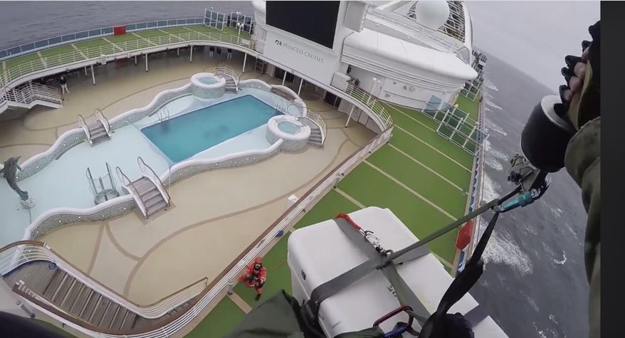 In this image from video, provided by the California National Guard, airmen with the 129th Rescue Wing drop virus testing kits down to the Grand Princess cruise ship off the coast of California Thursday, March 5, 2020. (California National Guard via AP)