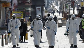 South Korean soldiers wearing protective gears spray disinfectant as a precaution against the new coronavirus in Seoul, South Korea, Thursday, March 5, 2020. The number of infections of the COVID-19 disease spread around the globe. (AP Photo/Lee Jin-man)