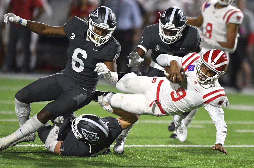 FILE - In this Friday, Oct. 25, 2019, file photo, Mater Dei quarterback Bryce Young is tackled after scrambling out of the pocket during a high school football game against St. John Bosco in Bellflower, Calif. Aside from being 2,000 miles away from his home in Southern California, the most challenging part of Alabama freshman quarterback Bryce Young's transition to college was dealing with two straight weeks of rainy weather in Tuscaloosa this winter. They don't get that in Pasadena, California. Otherwise, he's been too busy to be homesick. (Scott Varley/The Orange County Register via AP, File)
