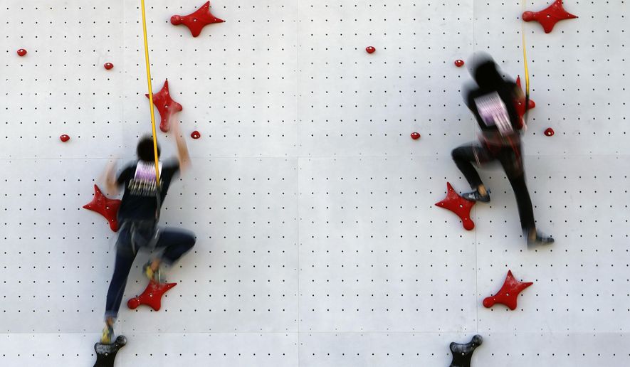 Tokyo 2020 Olympic Games Organizing staffs climb the wall in the test event of Speed Climbing in preparation for the Tokyo 2020 Olympic Games at Aomi Urban Sports Park Friday, March 6, 2020, in Tokyo. The recent outbreak of the coronavirus has forced them to cancel or postpone several. But they allowed a sport climbing event on Friday to go ahead, with a few restrictions: like the absence of elite athletes. (AP Photo/Eugene Hoshiko)