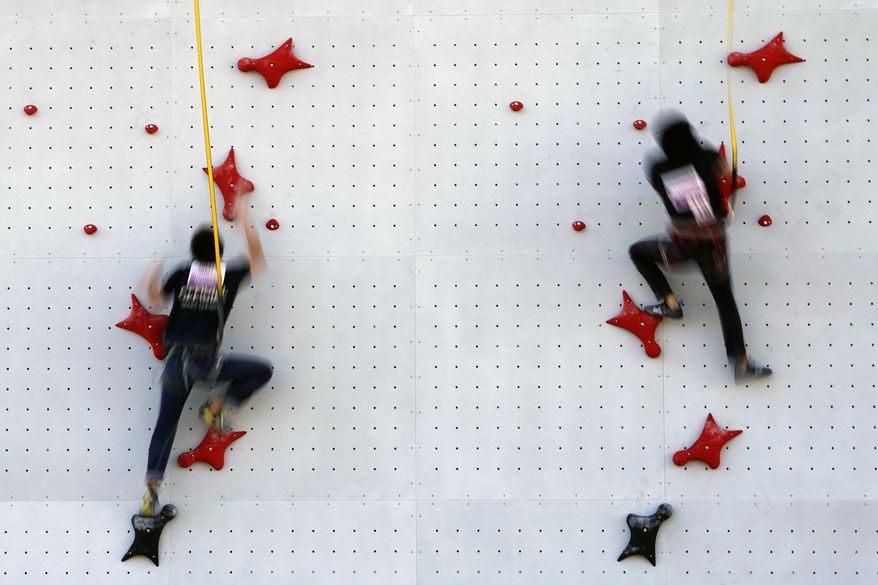 Tokyo 2020 Olympic Games Organizing staffs climb the wall in the test event of Speed Climbing in preparation for the Tokyo 2020 Olympic Games at Aomi Urban Sports Park Friday, March 6, 2020, in Tokyo. The recent outbreak of the coronavirus has forced them to cancel or postpone several. But they allowed a sport climbing event on Friday to go ahead, with a few restrictions: like the absence of elite athletes. (AP Photo/Eugene Hoshiko)