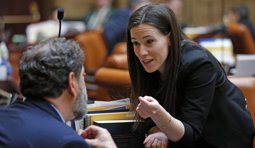 FILE - In this Feb. 22, 2019, file photo, Democratic Rep. Stephanie Pitcher speaks to Rep. Brian King on the house floor at the Utah State Capitol, in Salt Lake City. A proposal to limit the use of cash bail for people arrested in Utah is advancing in the Legislature. Passing the bill could avoid the possibility of lawsuit challenging the constitutionality of Utah&#39;s monetary bail system, which has happened in several other states, said the bill&#39;s sponsor, Pitcher. (AP Photo/Rick Bowmer, File)