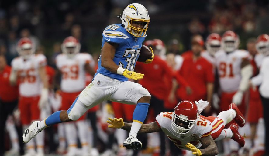 FILE - In this Nov. 18, 2019, file photo, Los Angeles Chargers running back Austin Ekeler, left, gets past Kansas City Chiefs strong safety Jordan Lucas, right, during the first half of an NFL football game in Mexico City. Ekeler’s breakout season with the Los Angeles Chargers has resulted in a contract extension. The running back has agreed to a four-year deal with the Chargers worth #24.5 million, including $15 million guaranteed. Ekeler was slated to be a restricted free agent when the new league year starts on March 18.(AP Photo/Eduardo Verdugo, File)