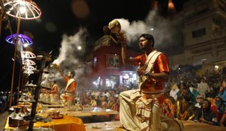 Hindu devotees watch as priests perform rituals during a prayer ceremony dedicated to holy river Ganges in Varanasi, India, Friday, March 6, 2020. India is bracing for a potential explosion of coronavirus cases as authorities rush to trace, test and quarantine contacts of 31 people confirmed to have the disease. Prime Minister Narendra Modi&#x27;s government said last week that community transmission is now taking place. India has shut schools, stopped exporting key pharmaceutical ingredients and urged state governments to cancel public festivities for Holi, the Hindu springtime holiday in which people douse each other with colored water and paint. (AP Photo/Rajesh Kumar Singh)
