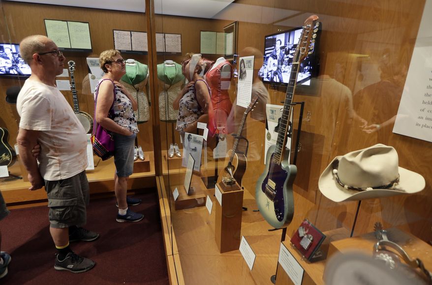 FILE - In this May 25, 2018 photo, visitors to the Country Music Hall of Fame and Museum in Nashville, Tenn. view the the Outlaws & Armadillos exhibit. The NRA has been publicizing plans to auction off firearms at a fundraising dinner at the Country Music Hall of Fame and Museum. But a spokesperson for the museum tells The Associated Press that the April event will not take place there after the AP asked questions about the museum's no firearms policy. (AP Photo/Mark Humphrey, File)