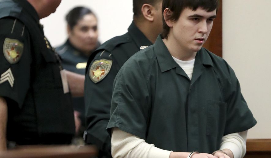FILE - In this Feb. 25, 2019, file photo Dimitrios Pagourtzis, the Santa Fe High School teenage student accused of killing 10 people in a May 2018 shooting at the high school, is escorted by Galveston County Sheriff's Office deputies into the jury assembly room for a change of venue hearing at the Galveston County Courthouse in Galveston, Texas. Pagourtzis was able to buy more than 100 rounds of ammunition online because his age was not verified, according to an amended lawsuit filed Thursday, March 5, 2020, alleging that the website involved broke federal law. Pagourtzis was a 17-year-old junior at the time of the May 2018 shooting at Santa Fe High School. (Jennifer Reynolds/The Galveston County Daily News via AP, Pool, File)