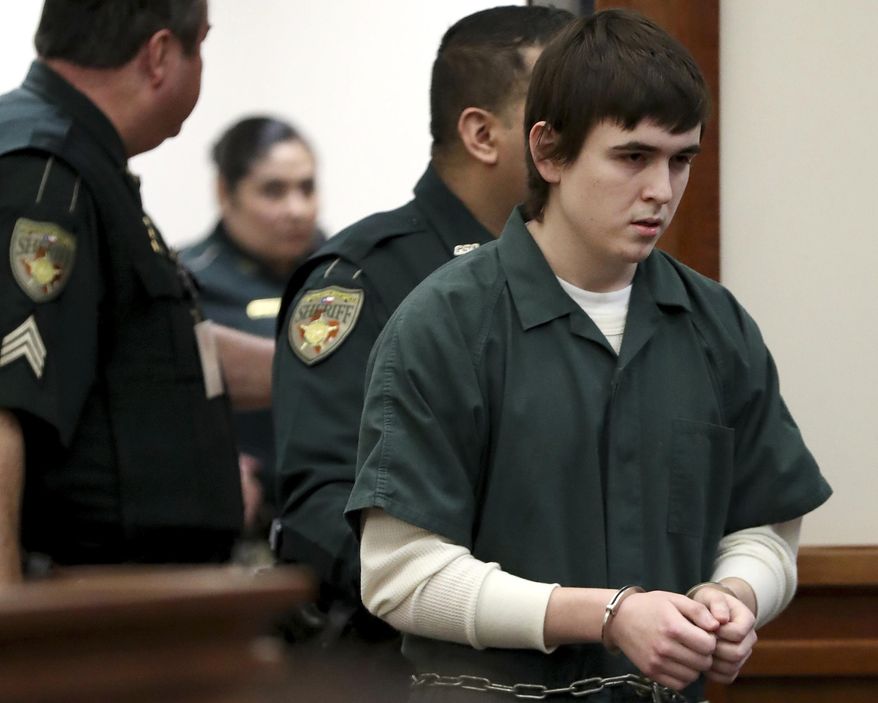 FILE - In this Feb. 25, 2019, file photo Dimitrios Pagourtzis, the Santa Fe High School teenage student accused of killing 10 people in a May 2018 shooting at the high school, is escorted by Galveston County Sheriff's Office deputies into the jury assembly room for a change of venue hearing at the Galveston County Courthouse in Galveston, Texas. Pagourtzis was able to buy more than 100 rounds of ammunition online because his age was not verified, according to an amended lawsuit filed Thursday, March 5, 2020, alleging that the website involved broke federal law. Pagourtzis was a 17-year-old junior at the time of the May 2018 shooting at Santa Fe High School. (Jennifer Reynolds/The Galveston County Daily News via AP, Pool, File)