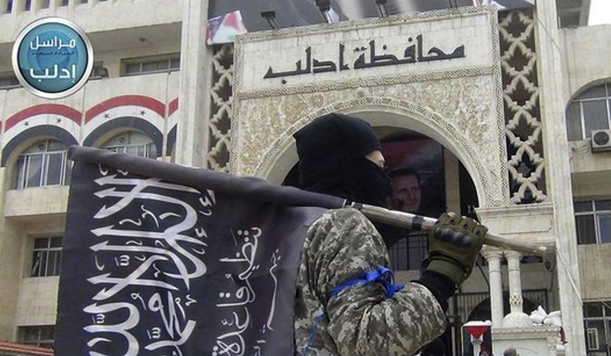 In this photo posted on the Twitter page of Syria&#x27;s al-Qaida-linked Nusra Front on March 28, 2015, a fighter from Syria&#x27;s al-Qaida-linked Nusra Front holds his group flag as he stands in front of the governor building in Idlib province, north Syria. Intermingled among 3 million civilians under siege in the Syrian government&#x27;s assault on the last opposition stronghold are tens of thousands of al-Qaida-linked fighters and other militants who came from around the world to take part in the country&#x27;s civil war. (Al-Nusra Front Twitter page via AP) **FILE**