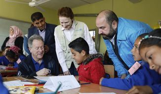 In this picture taken on March 3, 2020 and provided by UNICEF, UNICEF Executive Director Henrietta H. Fore, center, and WFP Executive Director, David Beasley, left, seated, interact with 3rd grade children, at Tal-Amara school, southern Idlib, Syria. Fore expressed hope in an interview with The Associated Press on Friday that a cease-fire that went into effect in Syria will hold so that children can return to normal life adding that nearly one third of Syria&#39;s children are out of school. Fore visited Syria this week where she met officials and toured villages on the edge of the northwestern province of Idlib. (Omar Sanadiki/UNICEF via AP )