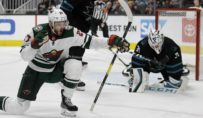 Minnesota Wild forward Alex Galchenyuk, left, celebrates after scoring a goal against San Jose Sharks&#x27; Martin Jones, right, in the second period of an NHL hockey game Thursday, March 5, 2020, in San Jose, Calif. (AP Photo/Ben Margot)