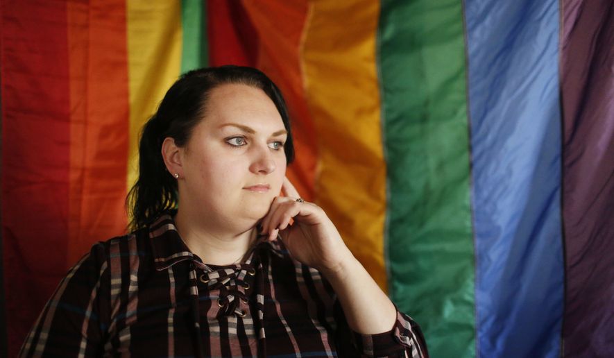 Destiny Clark of Odenville, Ala., sits in front of a pride flag for a portrait. Three transgender women including Clark have filed a lawsuit challenging Alabama&#39;s requirement for a person to show proof of sex-altering surgery in order to change the gender designation on their driver&#39;s license. (AP Photo/Brynn Anderson, File)