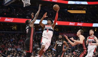 Washington Wizards forward Rui Hachimura (8), of Japan, goes to the basket next to Miami Heat forward Bam Adebayo (13), forward Solomon Hill (44) and guard Duncan Robinson, second from right, during the second half of an NBA basketball game, Sunday, March 8, 2020, in Washington. (AP Photo/Nick Wass) **FILE**