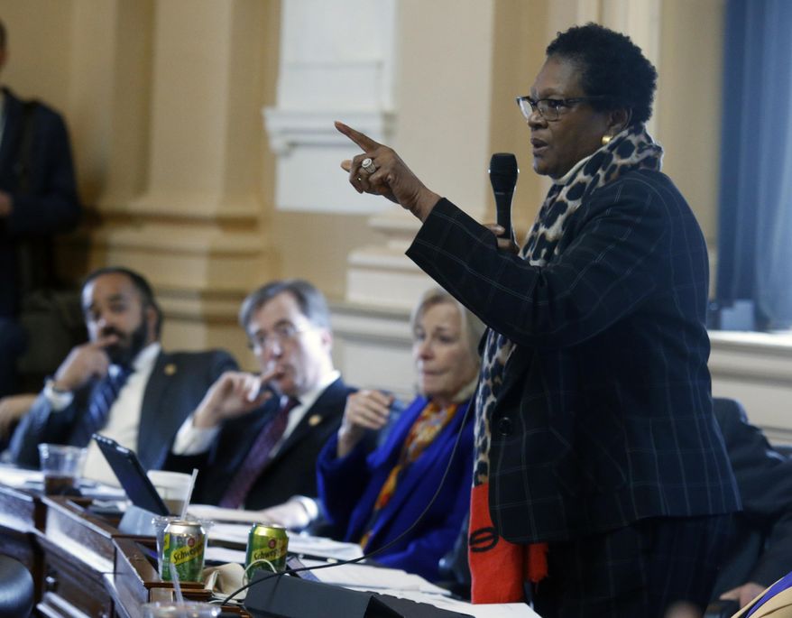 Del. Delores McQuinn, D-Richmond, right, gives an impassioned speech for passage of HB 1537, her bill that would allow the removal, relocation or altering memorials to war veterans, during the floor session of the Virginia House of Delegates inside the State Capitol in Richmond, VA Tuesday, Feb. 11, 2020. The bill passed, 53-46. Looking on are, from left, Del. Jeff Bourne, D-Richmond, Del. Rip Sullivan, D-Fairfax and Del. Kathleen Murphy, D-Fairfax. (Bob Brown/Richmond Times-Dispatch via AP)