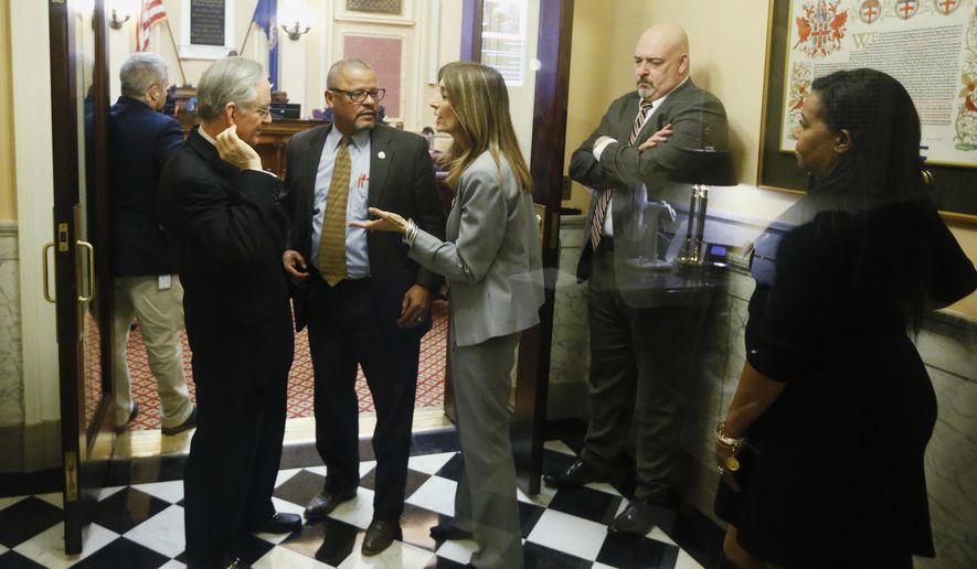 House Speaker Del. Eileen Filler-Corn, D-Fairfax, center, speaks to Sen. Tommy Norment, R-James City County, left, as Del. Luke Torian, D-Prince William, second from left, House minority leader Del Todd Gilbert, R-Shenandoah, and House majority leader, Del. Charniele Herring, D- Alexandria, look on in the entrance to the Senate at the Capitol Saturday March 7, 2020, in Richmond, Va. Both chambers agreed to extending the session to accommodate the budget and conference committee reports. (AP Photo/Steve Helber)